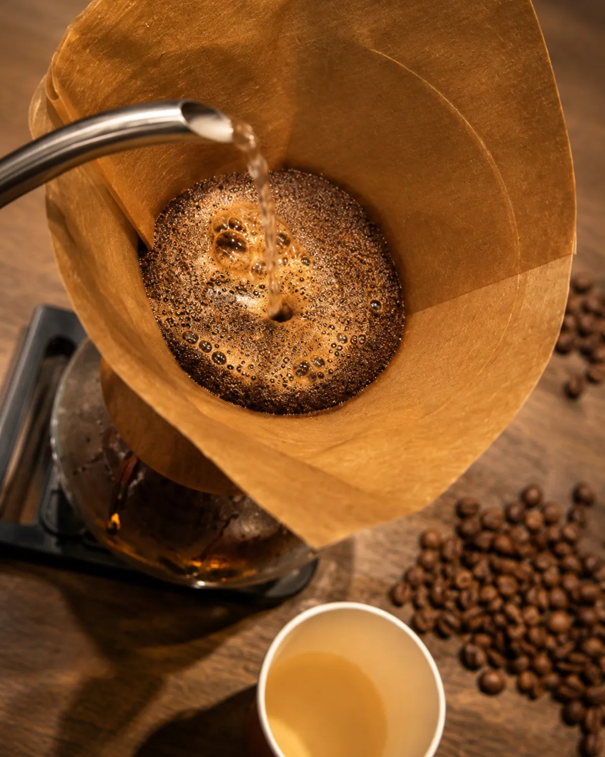 Café de filtro en preparación por método pour over, con granos de café